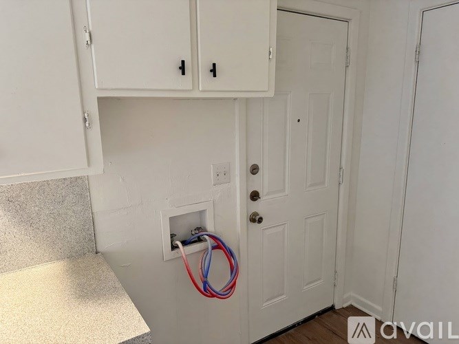 A white door with a small white cabinet above it.