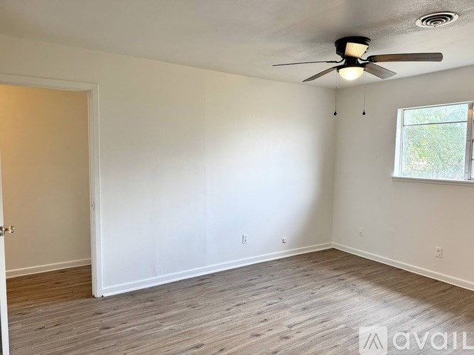 A room with a ceiling fan and a window.