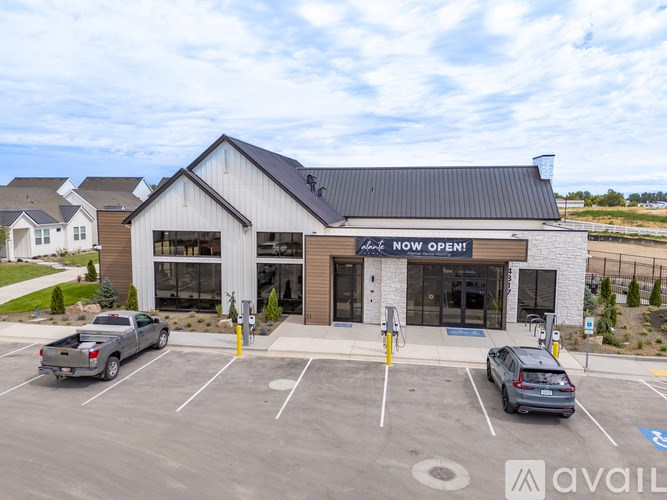 A car dealership with a sign that says "Now Open!" is shown.