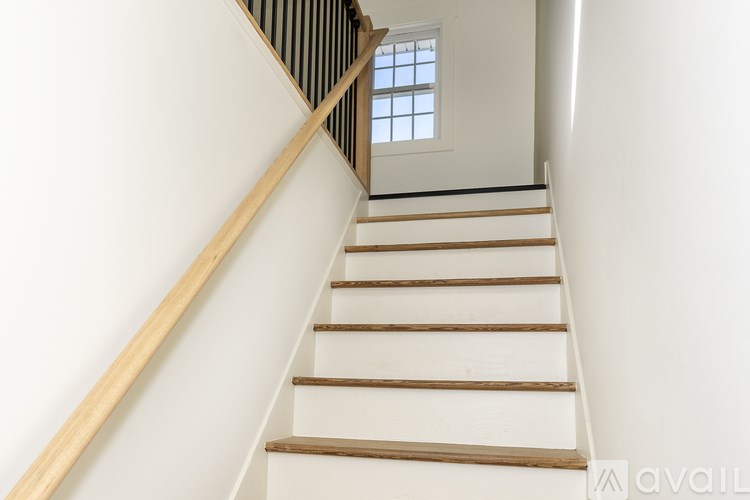 A staircase with wooden steps and a black railing.