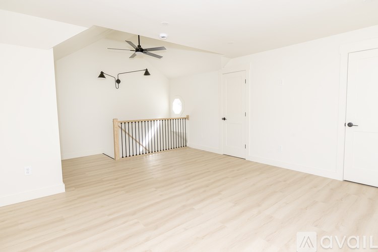 A room with a ceiling fan and a light fixture.