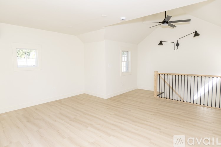 A spacious room with a ceiling fan and lighting fixtures.