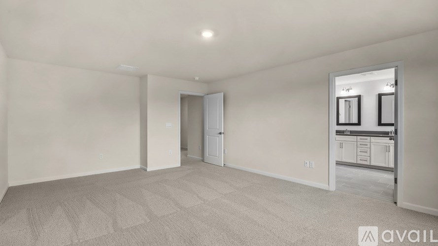 A spacious room with a carpeted floor and a doorway leading to another room.