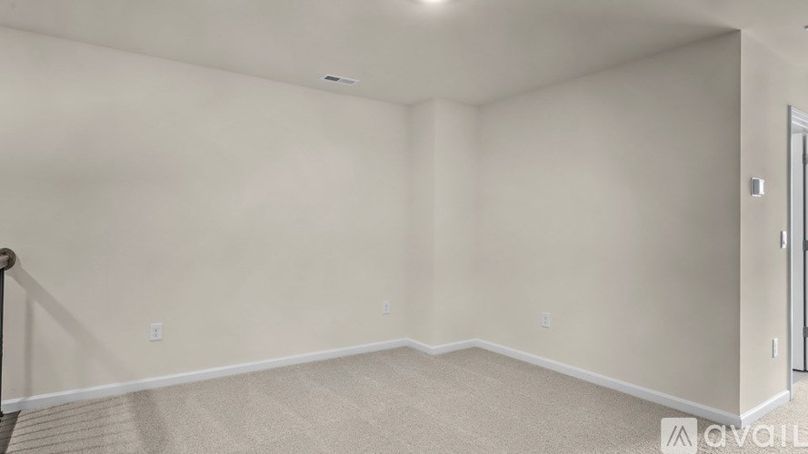 A room with beige carpet and white walls.