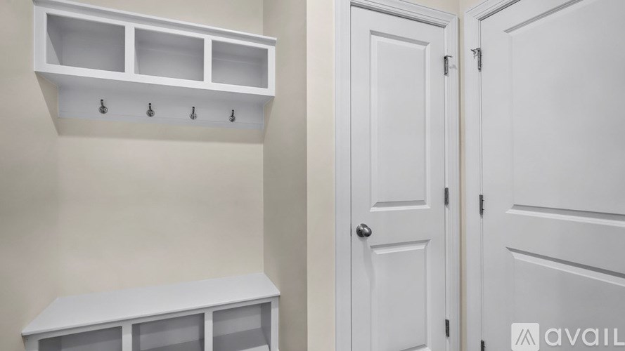 A white cabinet with glass doors and a white door with a handle.