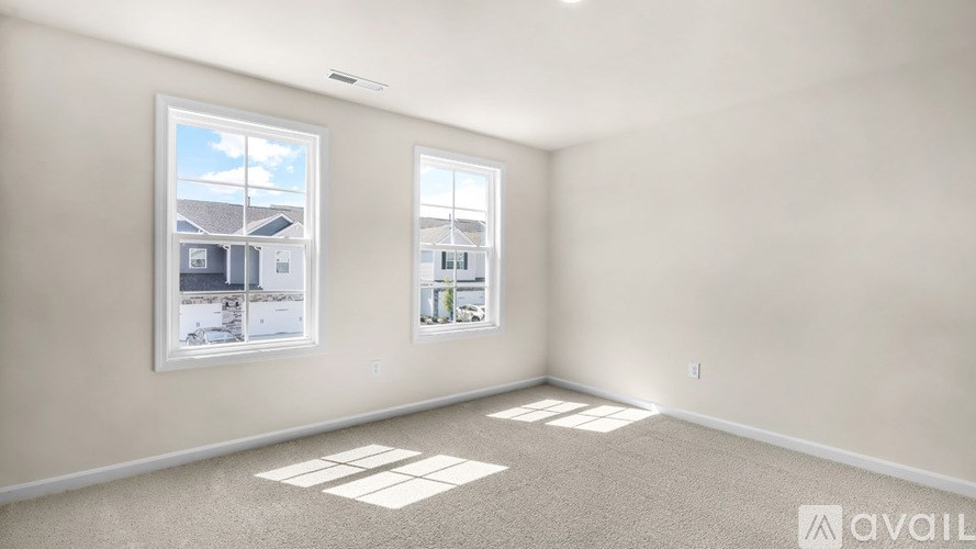 A room with two windows and a picture on the wall.