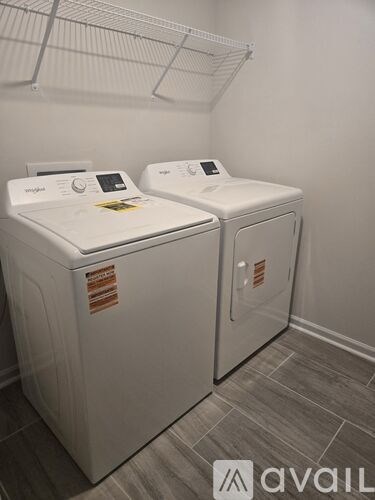 Two white washing machines in a laundry room.