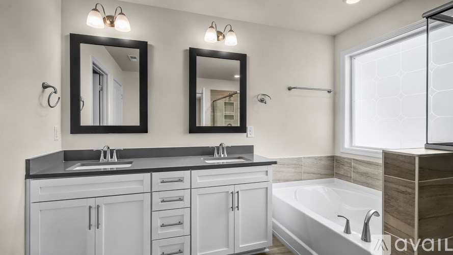 A bathroom with a black countertop and white cabinets.