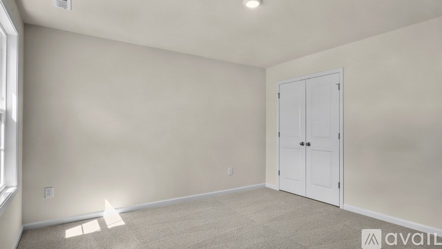 A room with a white door and carpeted floor.