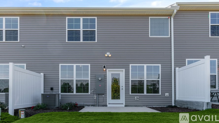 A grey house with a white door and windows.