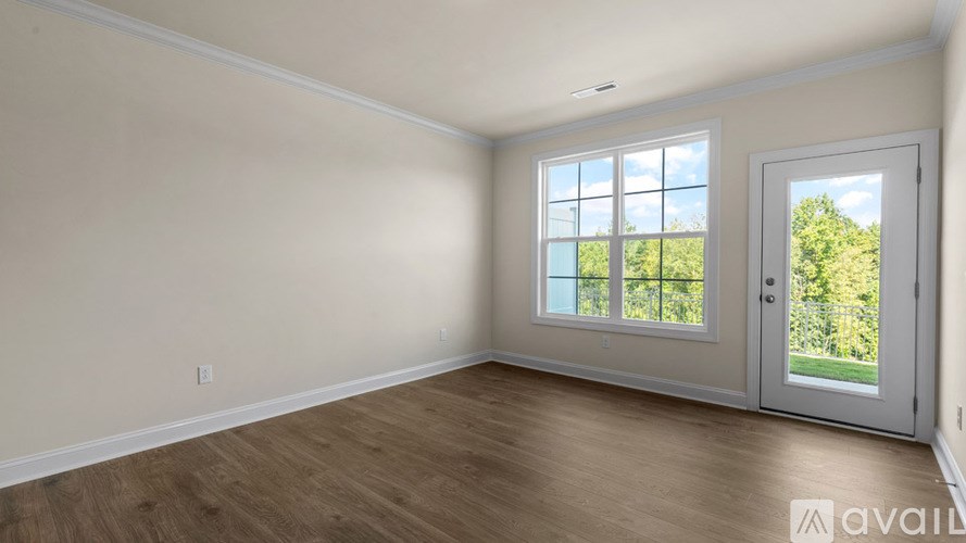 A room with a large window and a sliding door leading to a garden.