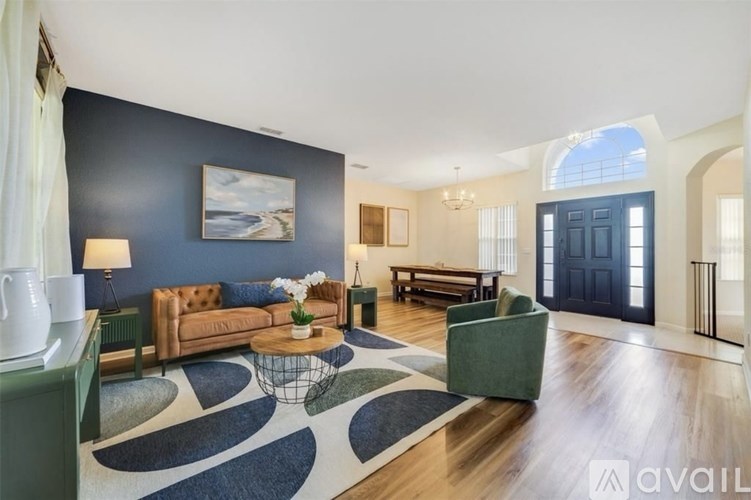 A living room with a brown sofa, a green armchair, and a coffee table.