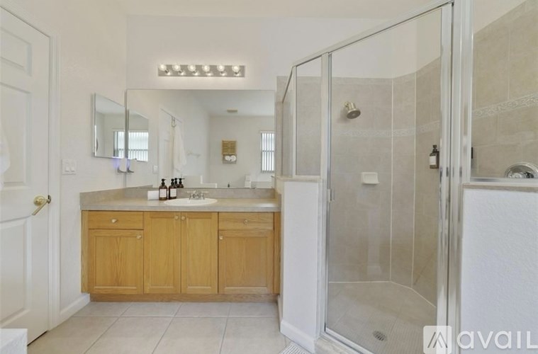 A bathroom with a double sink vanity and a walk-in shower.