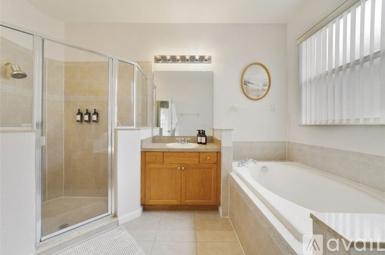 A bathroom with a tub, sink, and shower.