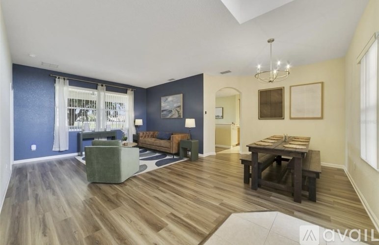 A living room with a wooden floor and furniture.