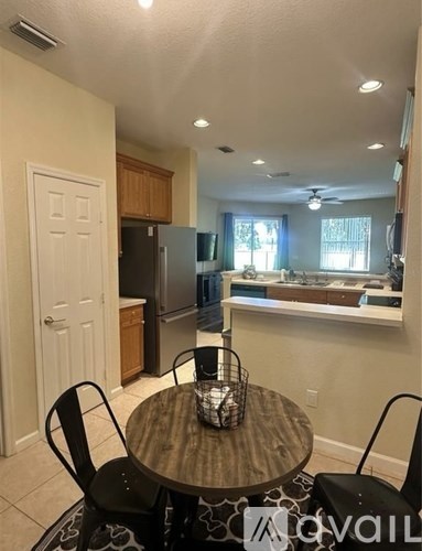 A kitchen with a table and chairs in the foreground.