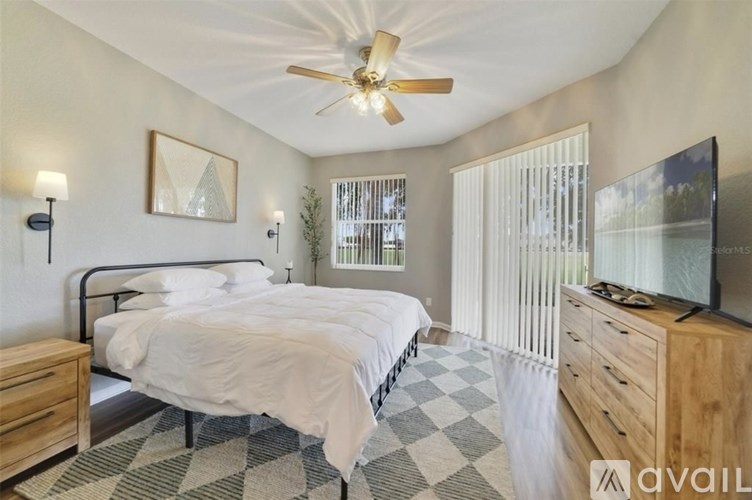 A bedroom with a bed, dresser, and television.