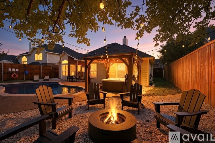 A backyard with a fire pit and chairs.