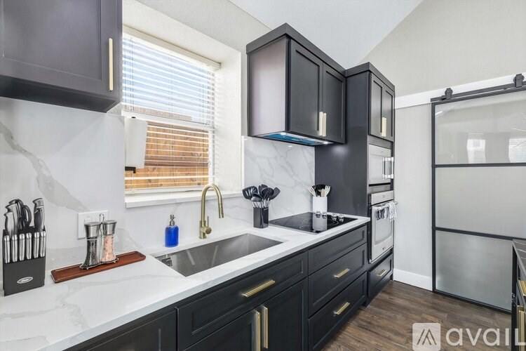 A kitchen with black cabinets and a white countertop.