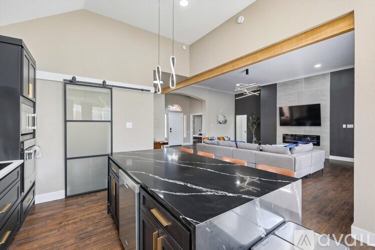 A modern kitchen with a black granite countertop and stainless steel appliances.