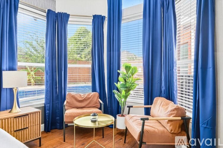 A living room with blue curtains and a glass table.