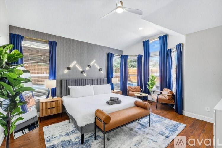 A well-lit bedroom with a large bed and a ceiling fan.