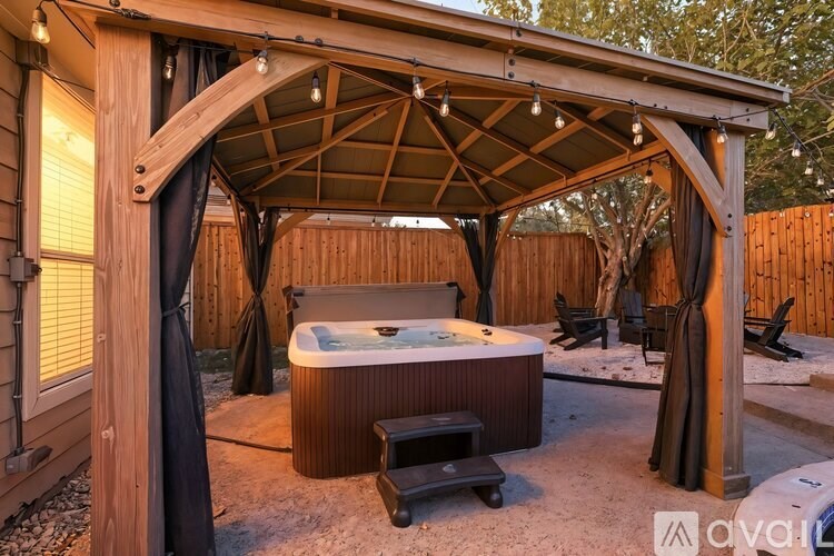 A wooden hot tub is surrounded by a wooden pergola.