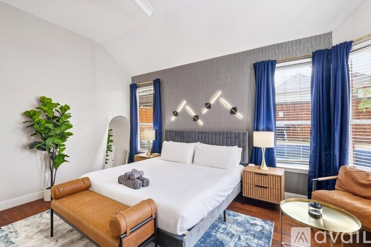 A bedroom with a large bed and a plant.