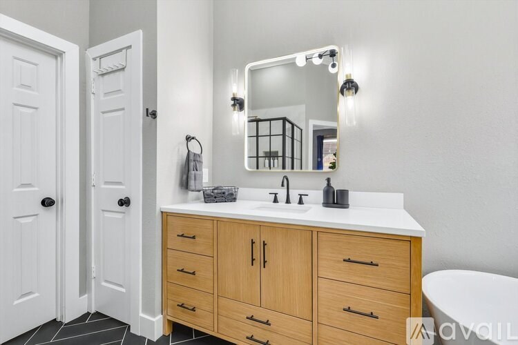 A bathroom with a white countertop and wooden cabinets.