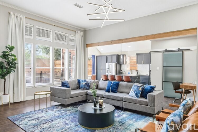 A living room with a grey couch and a blue rug.