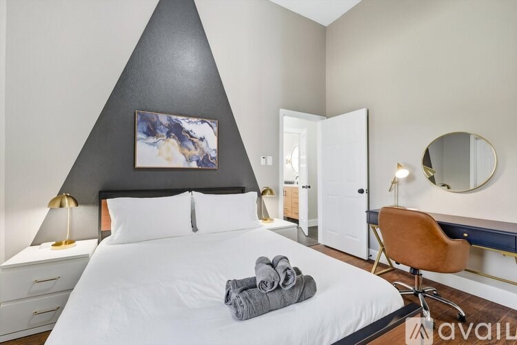 A bedroom with a large bed and a chair.