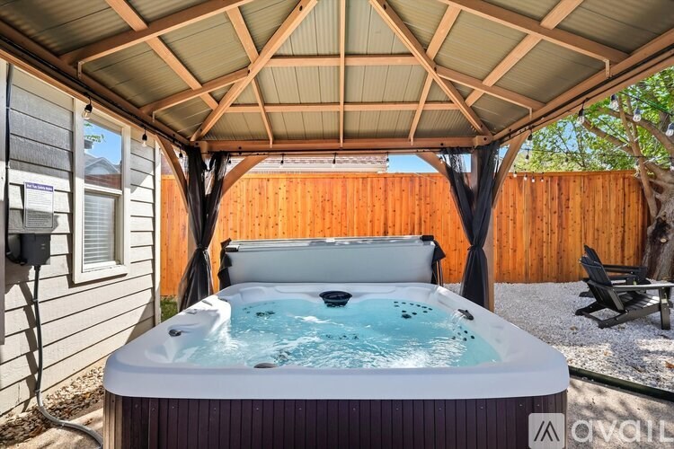 A hot tub is in the middle of a covered patio.