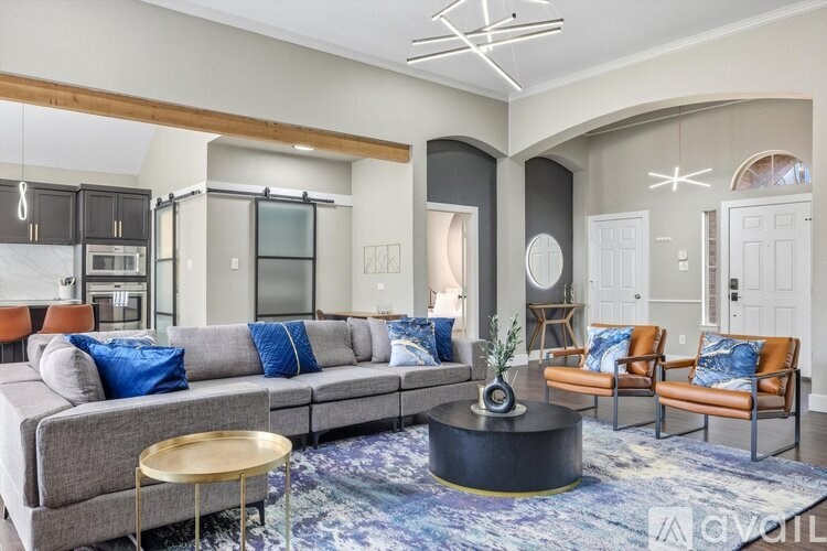 A modern living room with a grey sofa, a round coffee table, and a rug with a blue pattern.