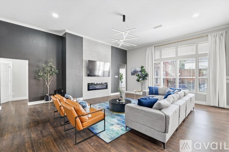 A modern living room with a grey sofa, a fireplace, and a large window.