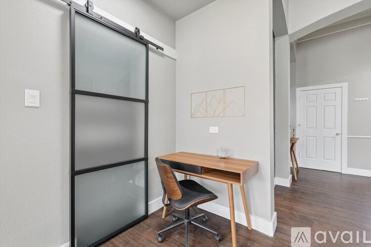 A room with a desk and chair in it.