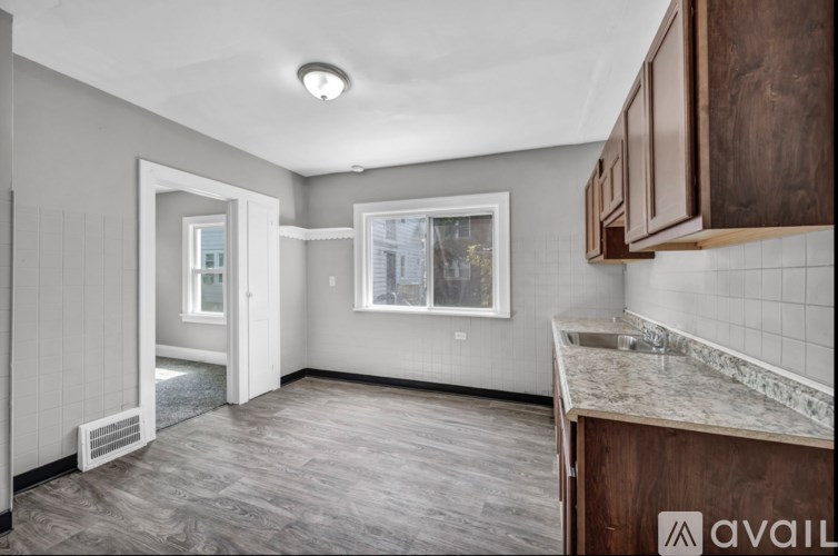A kitchen with a marble countertop and wooden cabinets.