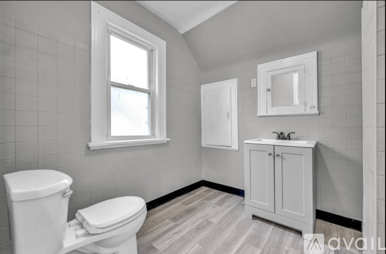 A bathroom with a toilet, sink, and medicine cabinet.