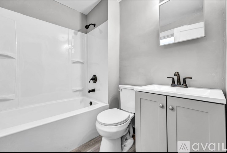 A white bathroom with a toilet, sink, and bathtub.