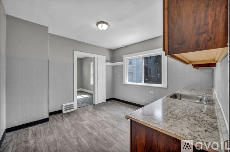 A kitchen with a marble countertop and wooden cabinets.