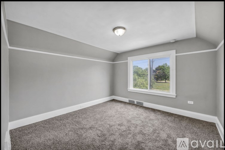 A room with a window and carpeted floor.