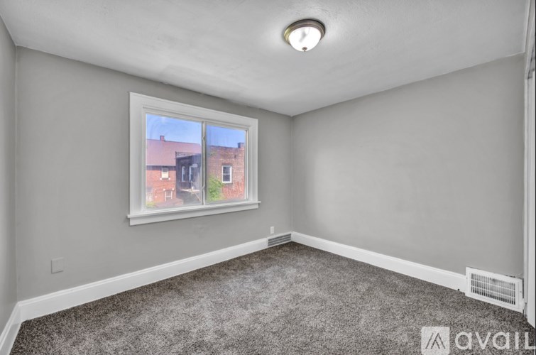 A room with a window showing a view of a building outside.