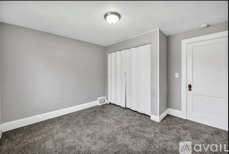 A room with grey carpet and white doors.