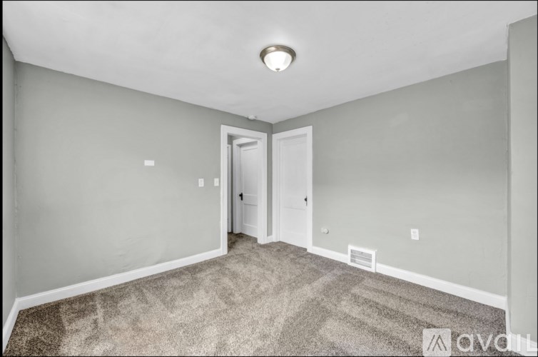 A room with a carpeted floor and a ceiling light.