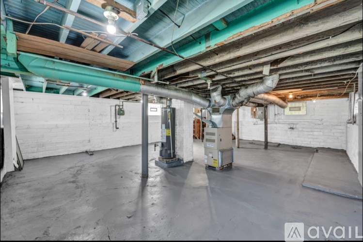 A spacious basement with a concrete floor and exposed pipes.