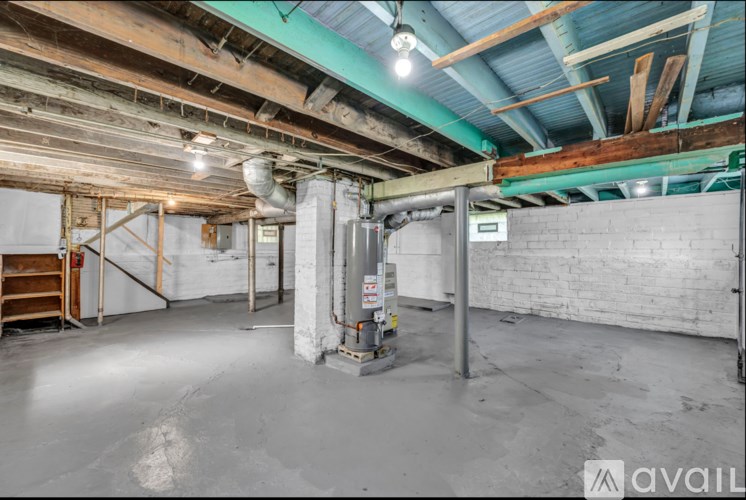 A large, empty room with a brick wall and a wooden beam ceiling.