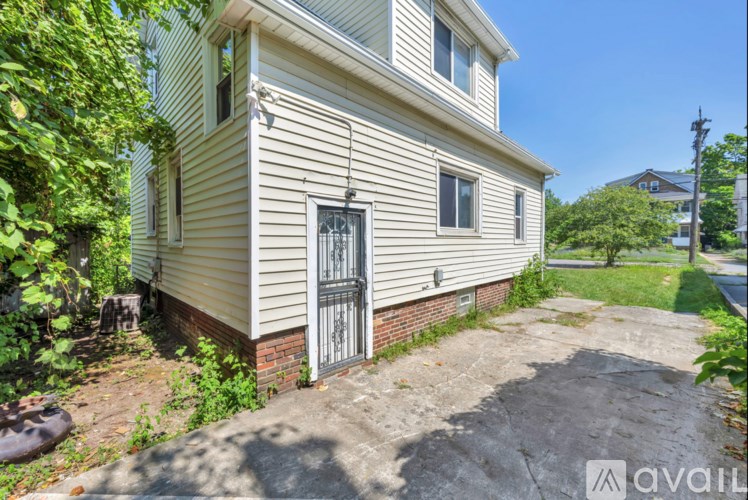 A house with a grey door and windows surrounded by greenery.