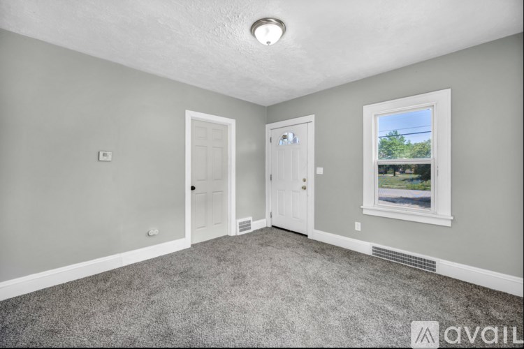 A room with grey carpet and two white doors.