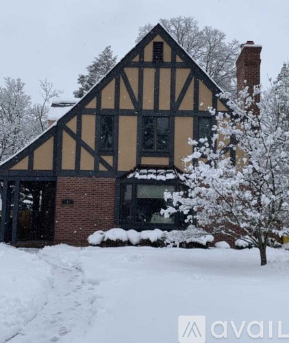 A house with a black and white facade stands in the snow.
