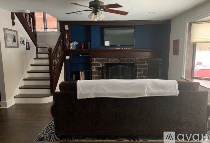 A living room with a brown couch and a fireplace.
