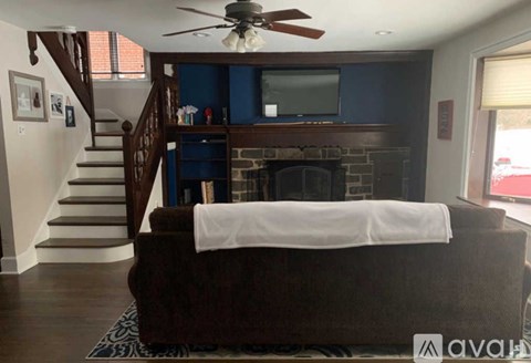 A living room with a brown couch and a fireplace.